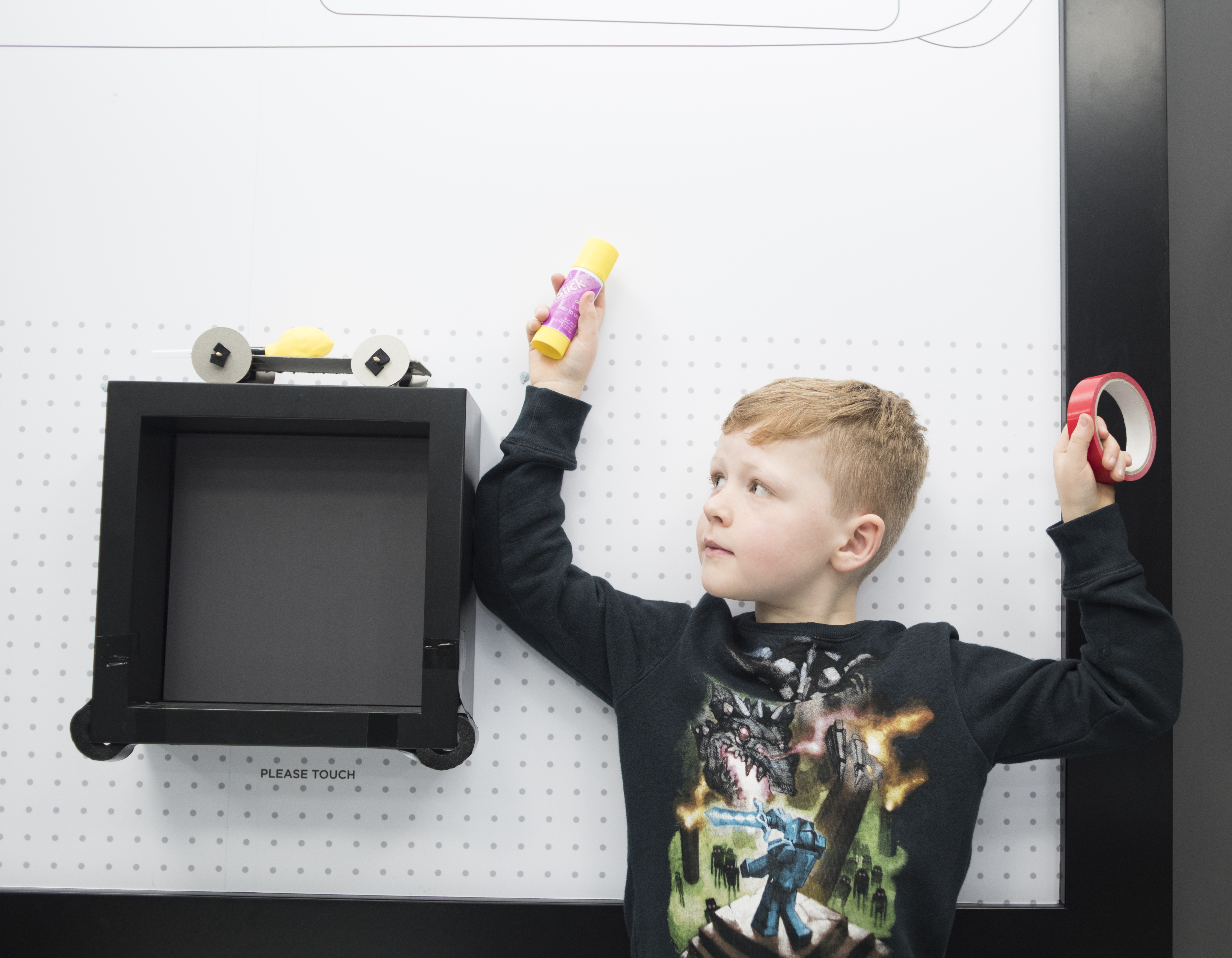 Boy holding glue stick and tape