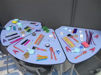 objects on a table including straws, sponges, cups and tape