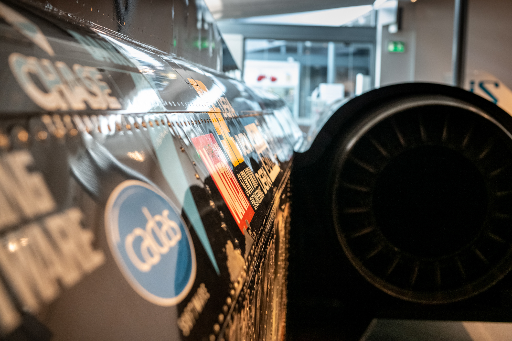 A side view of a section of Thrust SSC featuring logos from partner companies printed on the side of the car