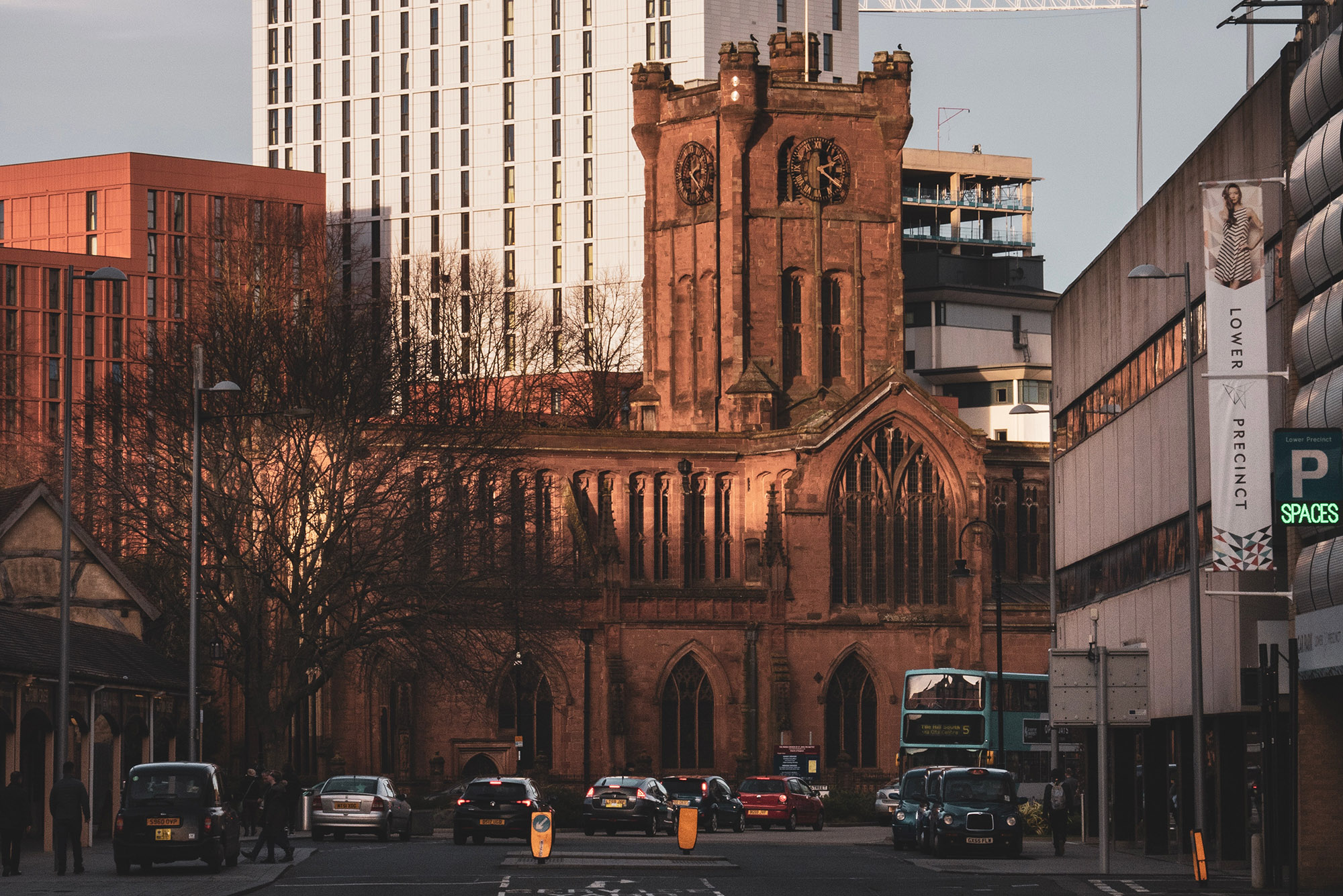 A photo of Corporation Street in Coventry, with the lower precinct car park on the right hand side, looking towards St John the Baptist church