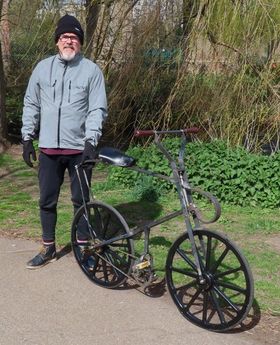 A photo of Edwin Knight standing next to his proof of concept for the Sussex Dwarf safety bicycle