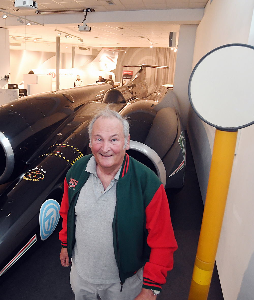 Richard Noble standing next to Thrust SSC in Coventry Transport Museum