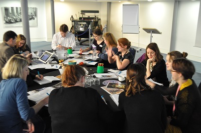 group of people round a table with papers and pens