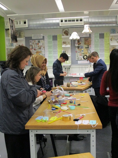 a group of students around a table of craft items